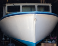 White boat with blue trim inside a garage
