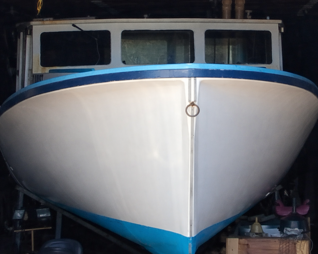 White boat with blue trim inside a garage
