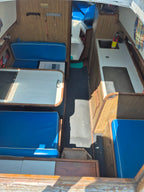 Interior of a vehicle with blue seats and wooden panels