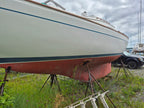 Boat on a lift in a grassy area with a cloudy sky