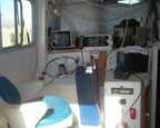 Interior of a small vehicle with dashboard, steering wheel, and seats.