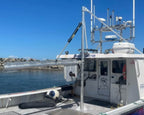 Boat docked at a pier with clear blue sky and water in the background