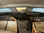 Interior of a vehicle with a sunroof and reflective sunshades.