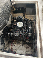 Engine compartment of a vehicle with visible wiring and components.