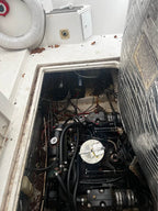 Engine compartment of a vehicle with visible wiring and components.