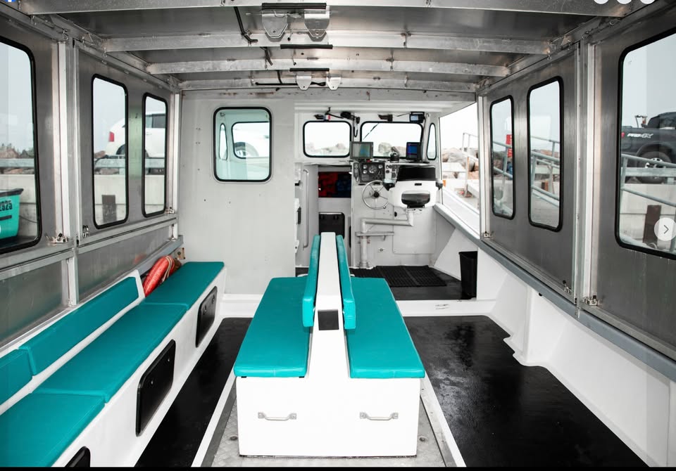 Interior of a vehicle with teal benches and large windows