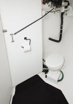 Compact bathroom with a toilet and shower setup in a small space