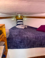 Bed with blue bedding and pillows in a compact room