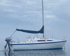 Sailing boat on calm water with a cloudy sky