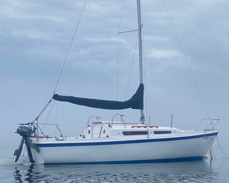 Sailing boat on calm water with a cloudy sky
