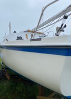 Sailing boat with 'MacGregor' branding on a grassy area