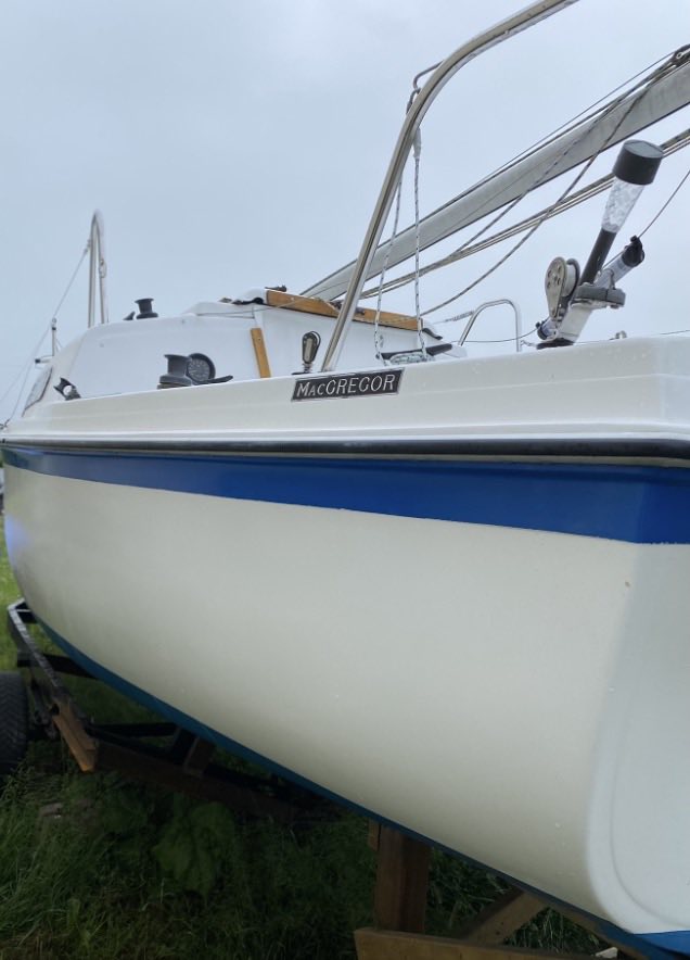 Sailing boat with 'MacGregor' branding on a grassy area