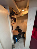 Small storage room with shelves, boxes, and various items.