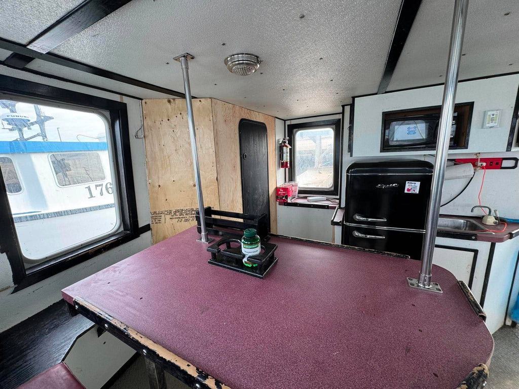 Interior of a recreational vehicle with a table, sink, and various items.