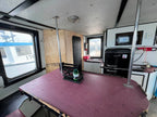 Interior of a recreational vehicle with a table, sink, and various items.
