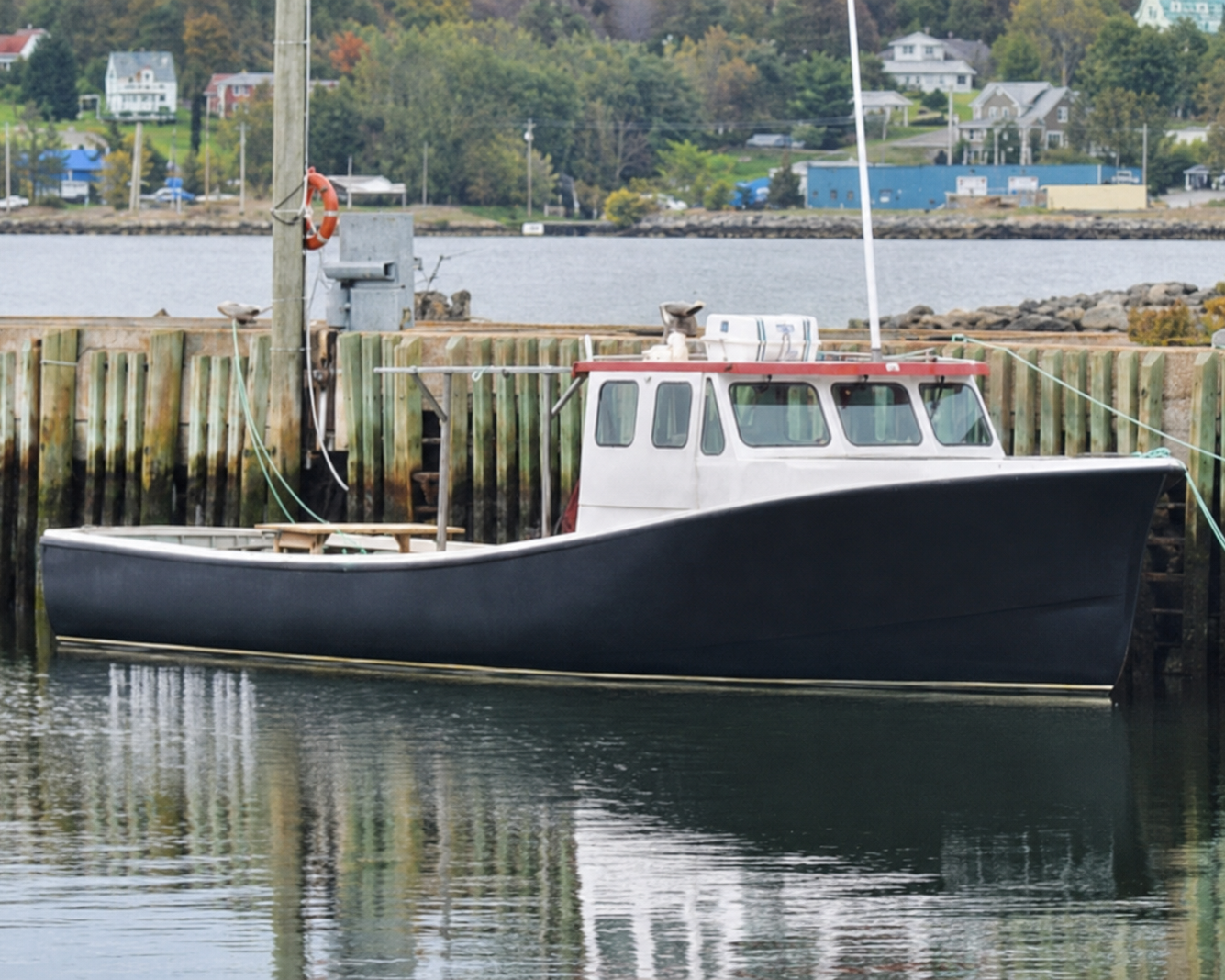 Boat docked at a pier with a calm water background