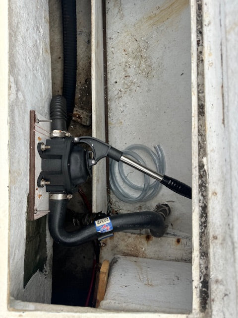 Pump and hoses inside a metal compartment