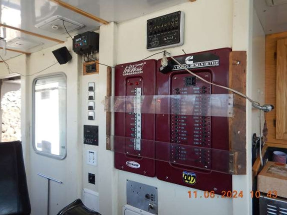 A vintage marine navigation console with a large red Anmark 'The Mast Haul' control panel, mounted on a cream-colored wall inside a boat cabin.
