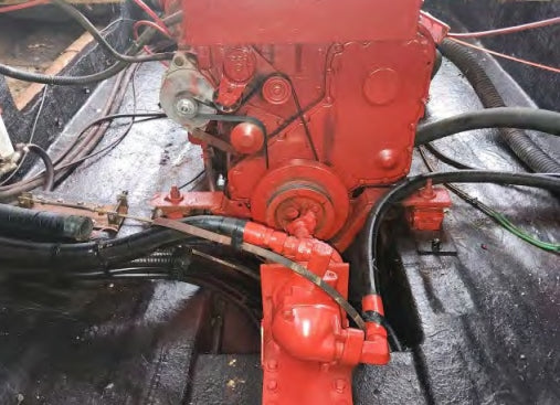 Close-up of a red mechanical component with various pipes and wires on a dark background