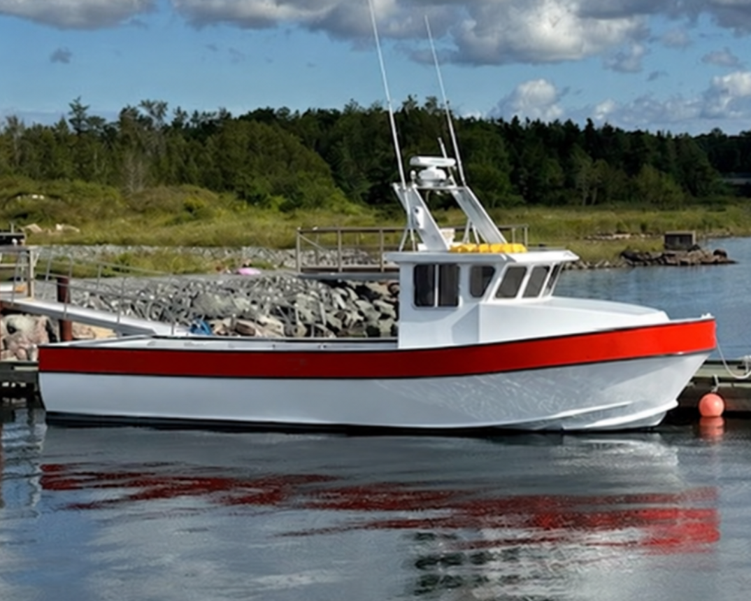 A white fishing boat with a red stripe along the hull is docked at a harbor under a blue sky with large white clouds. Trees and rocks line the shore in the background, with another boat and dock structures visible.